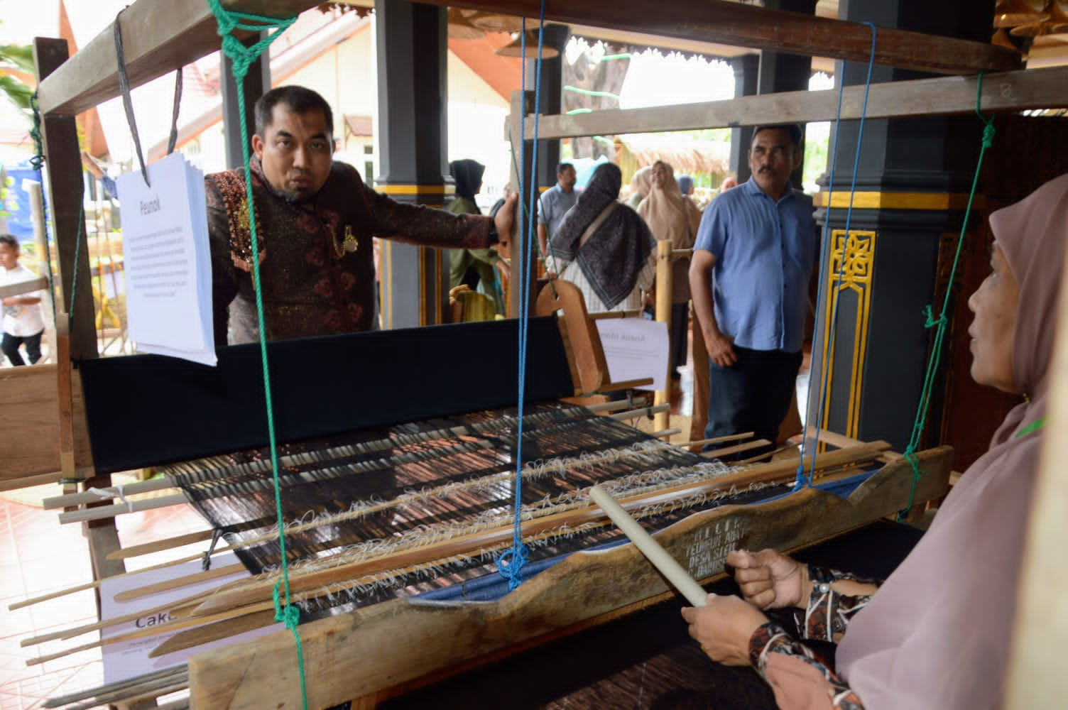 Pj Bupati Aceh Besar, Muhammad Iswanto SSTP MM (kiri) berbincang dengan pengrajin Teunun tradisional (Teupen) yang berdiri tahun 1970 ditampilkan di Anjongan Aceh Besar PKA-8 Taman Sulthanah Safiatuddin, Banda Aceh, Minggu (05/11/2023). (Foto : MC. Aceh Besar).