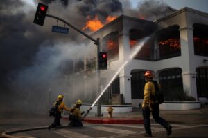 Seorang petugas pemadam kebakaran menggunakan selang untuk memadamkan api di kawasan Pacific Palisades Los Angeles California AS 8 Januari 2025. REUTERSDaniel Cole